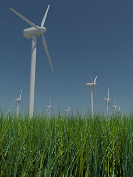 Several windmills standing in the field with grass against the blue sky a bright sunny, windless summer day