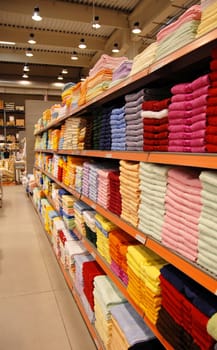 new colorful towels stacks on shelves in store