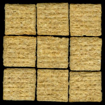 nine baked whole wheat crackers with rosemary isolated on black