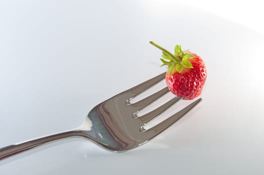 Single strawberry on a fork.