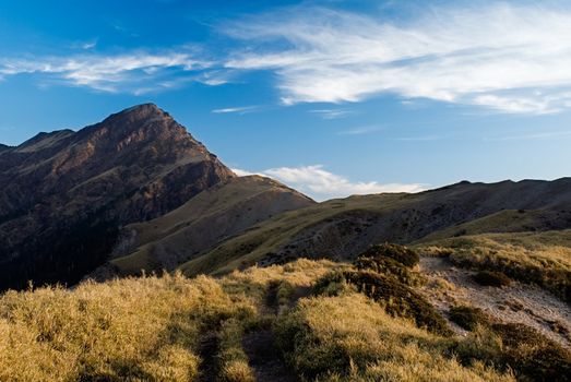 Sunset high mountain with beautiful clouds and soft grassland.