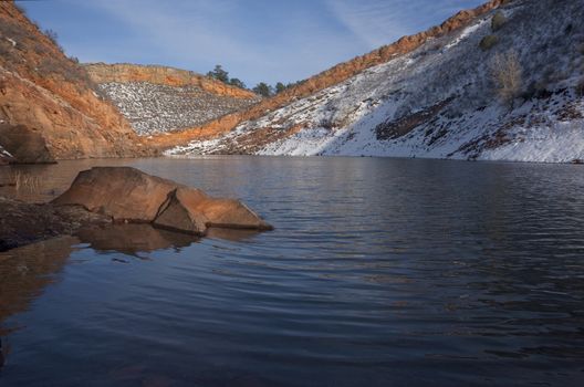 mountain lake in Colorado  (Horestooth Reservoir near Fort Collins) in early spring with red sandstone cliffs and snow