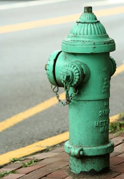 A old green Fire hydrant on the street