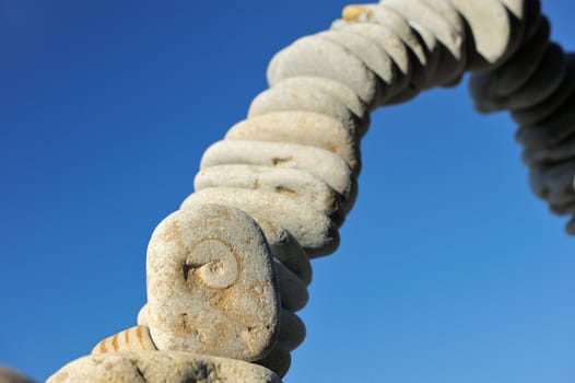 Air arc of pebbles in the blue sky