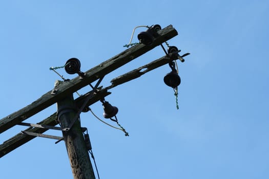 A old telephone pole against blue sky