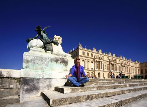 The woman meditates on a background of Chapel of Versailles Palace. France
