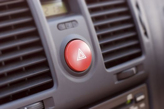 A car dashboard, narrow depth field focusing on the hazard-warning button