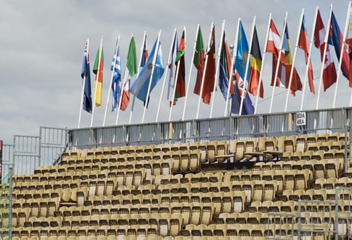 Rows of seats in a temporary stadium with flags of various nations