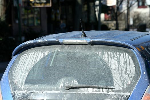 A car covered on road salt in winter