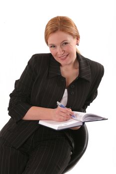 Smiling woman with pen and notebook on chair
