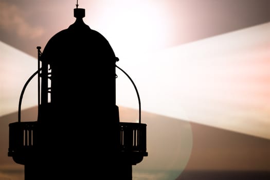 lighthouse captured with the sun behind it and beams on