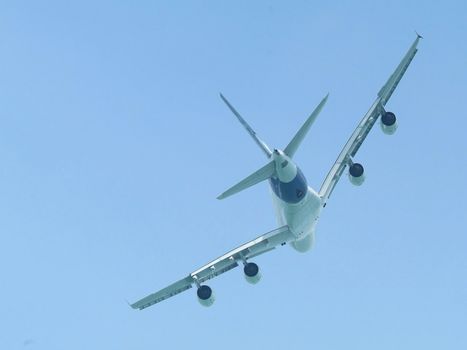 Very large wide-body airliner flying, seen from behind