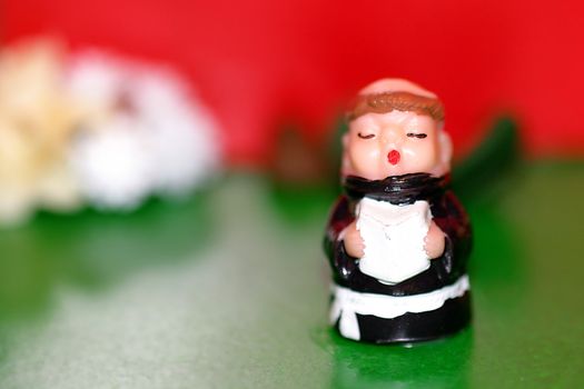A toy monk in front of a red and green background