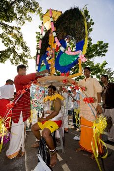 man preparing to carry a heavy kavadi decorated to please the deity