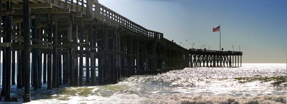 The Ventura Pier with waves and the flag at the end.