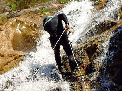 Men descending waterfall in Portugal