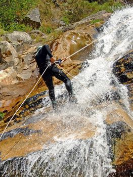 Men descending waterfall in Portugal