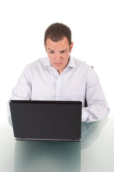 A handsome young man, acting surprised while using his laptop computer. Isolated on white.