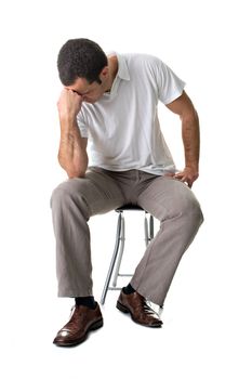 A young man, sitting on a stool, thinking. Isolated on white background.