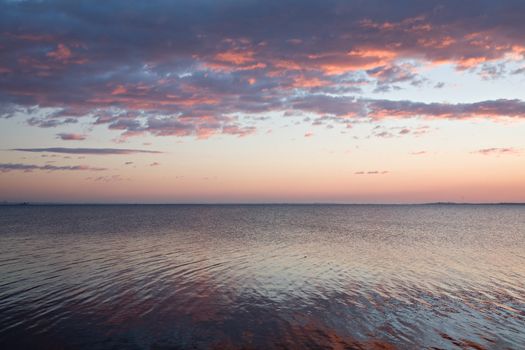 Photo of horizon over water surface at sunset.