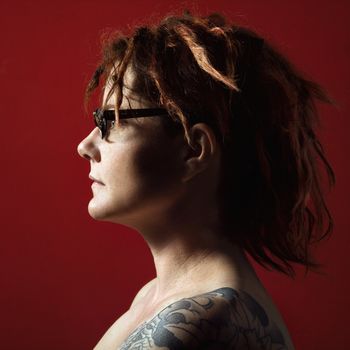 Profile portrait of adult woman with tattoos.