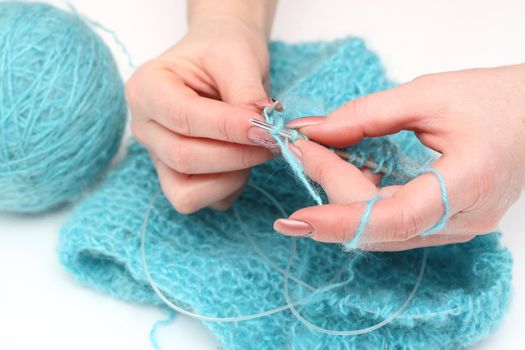 woman hands knitting a turquoise pullover