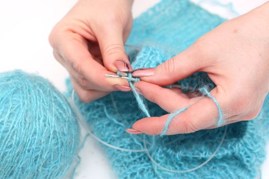 woman hands knitting a turquoise pullover