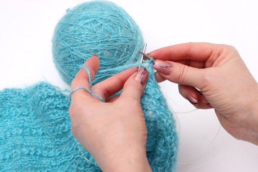 woman hands knitting a turquoise pullover