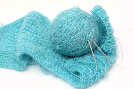 knitting a turquoise pullover and ball of a turquoise yarn