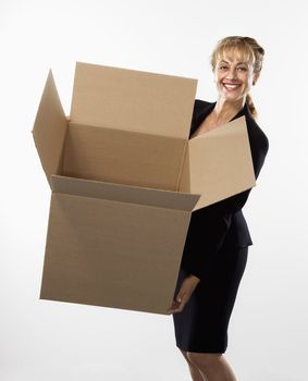 Caucasian businesswoman standing holding empty cardboard box smiling at viewer.