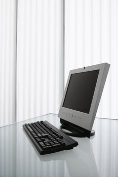 Flat screen computer monitor and keyboard on a desk.