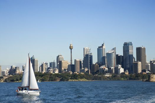 Skyscrapers and sailboat on Sydney Harbour in Sydney, Australia.