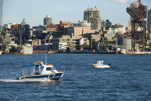 Water taxi boat in Sydney, Australia with city buildings.