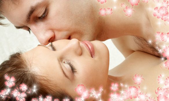 sweet couple kissing in bed with flowers