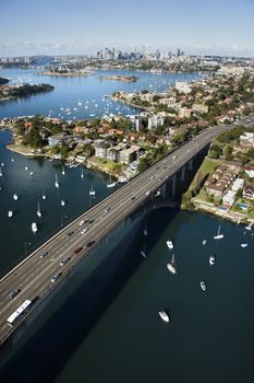 Aerial view of Victoria Road bridge and boats with distant downtown skyline in Sydney, Australia.