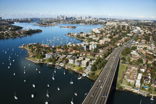 Aerial view of Victoria Road bridge and boats with distant downtown skyline in Sydney, Australia.