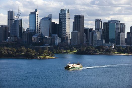 Aerial view ferryboat crossing harbour with skyline of Sydney, Australia.