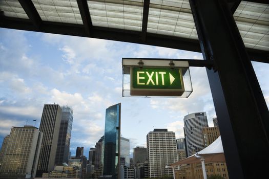 Exit sign with view of buildings in downtown Sydney, Australia.