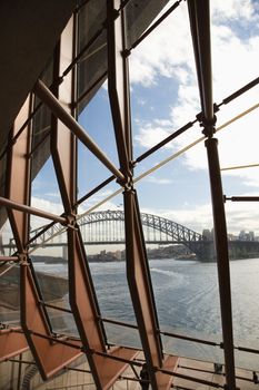 View from inside looking through windows to Sydney Harbour Bridge in Australia.