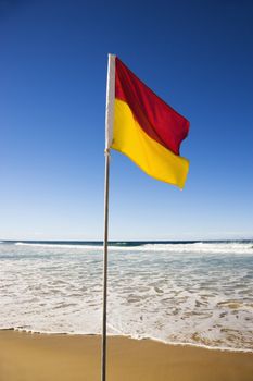 Red and yellow flag on beach in Surfers Paradise, Australia.