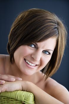 Bare Caucasian mid adult brunette woman smiling at viewer.