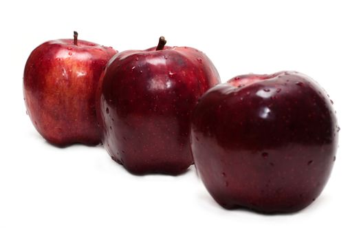 Three red apples, in droplet grow insulated on white background