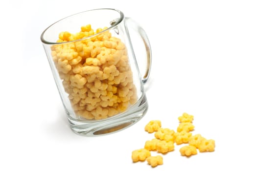 Glass cup full dry morning meal, disposit flakes on white background