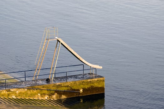 Slider by the calm sea over a concrete pier