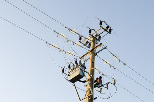 Electricity pole and wiring against the blue sky