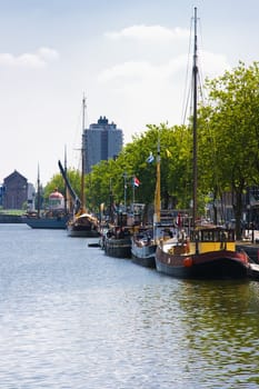 Small harbor in city with ships on summer day