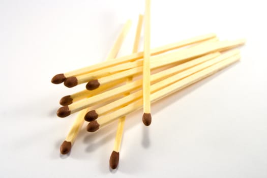 Pile of matches with brown tips on a white background