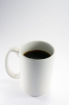 White coffee mug with black coffee from a top view on a white background