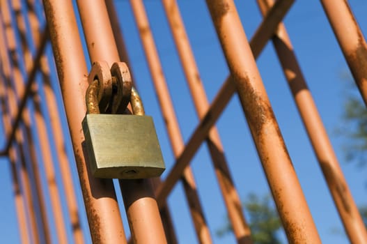 Rusty cage detail painted in red against the sky