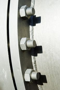 Connection detail in a pipework showing painted gray nuts and bolts